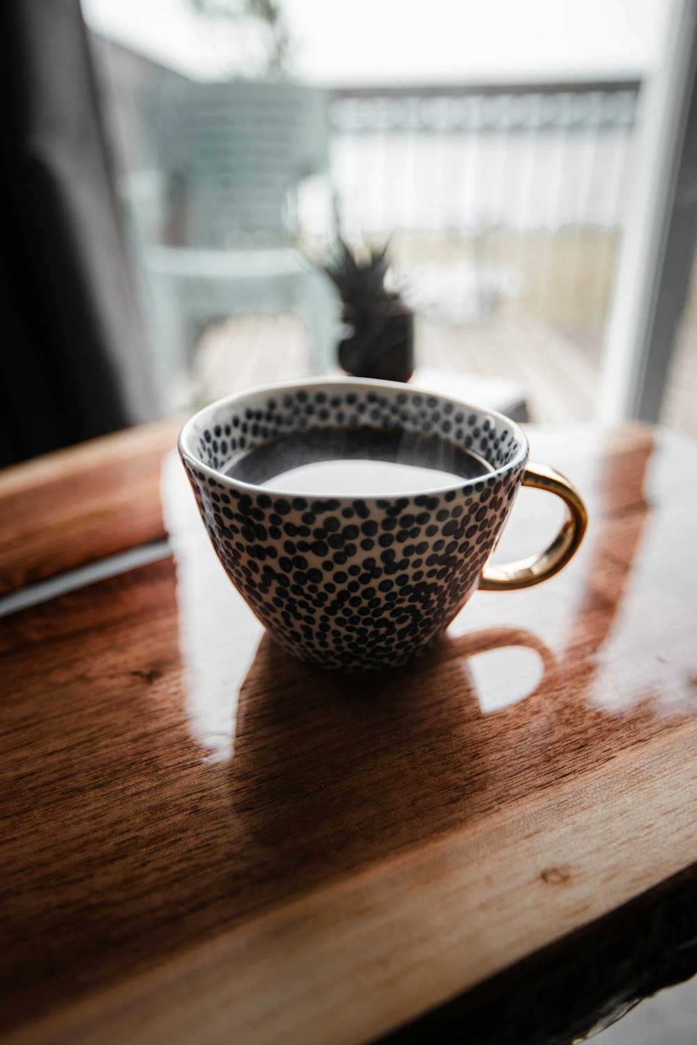 white and black ceramic teacup on brown wooden table