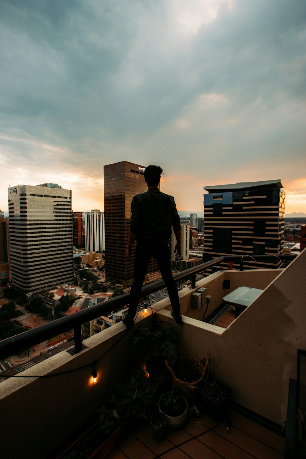 man in black jacket standing on top of building during daytime