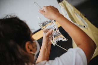 woman in white shirt holding iv infusion bag