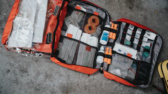 A neatly arranged first aid kit with bandages and antiseptics on a wooden table