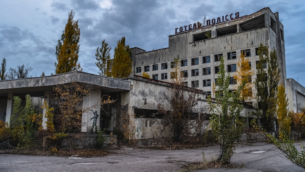 edifício de concreto branco perto de árvores verdes sob nuvens brancas durante o dia