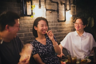 woman in black and white floral dress sitting beside man in white crew neck t-shirt