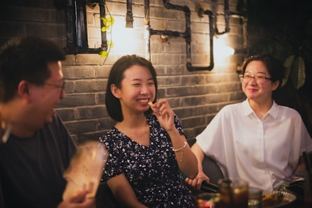 woman in black and white floral dress sitting beside man in white crew neck t-shirt