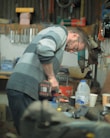 man in gray and blue striped polo shirt and blue denim jeans holding red and white