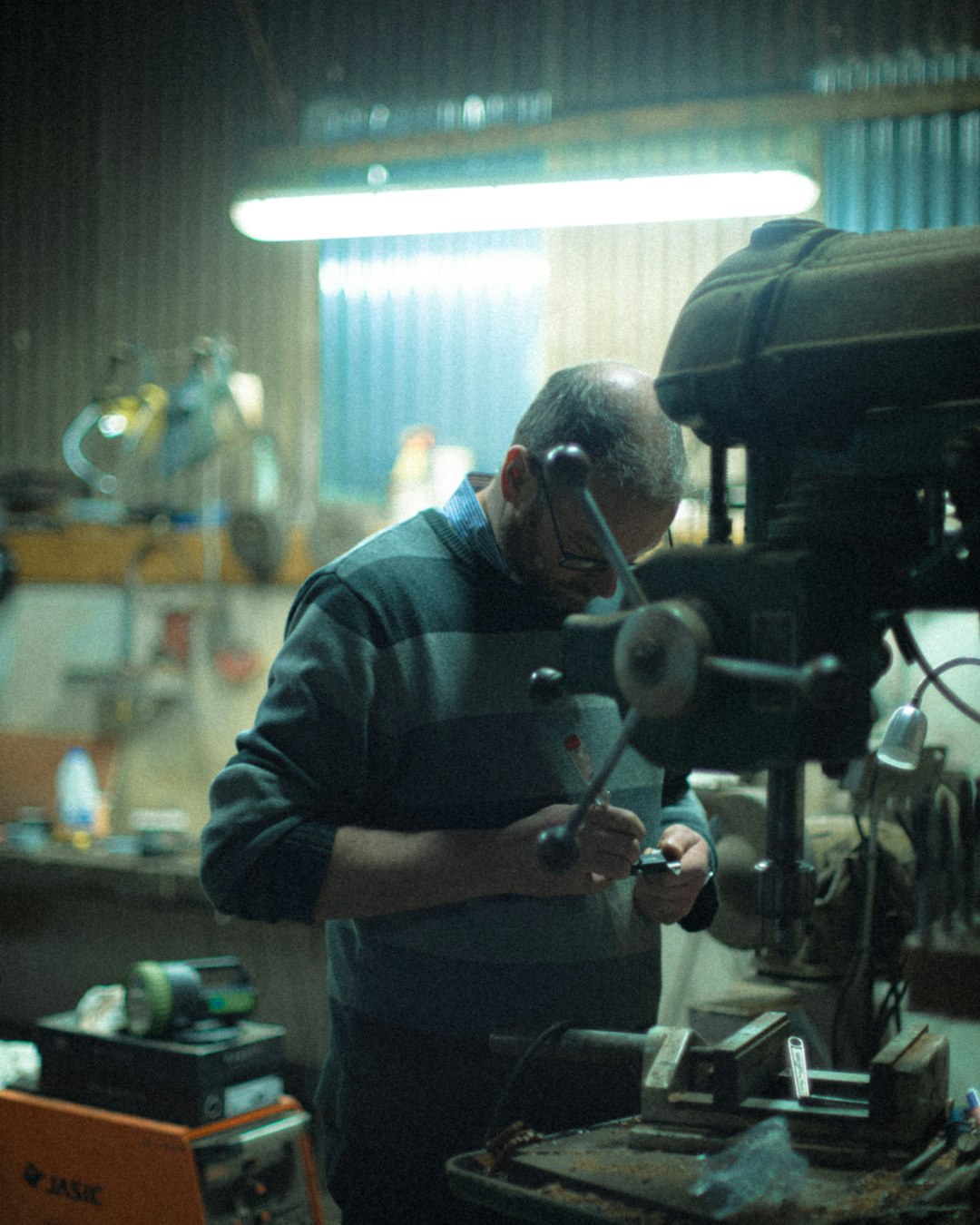 man in gray dress shirt using black and gray power tool