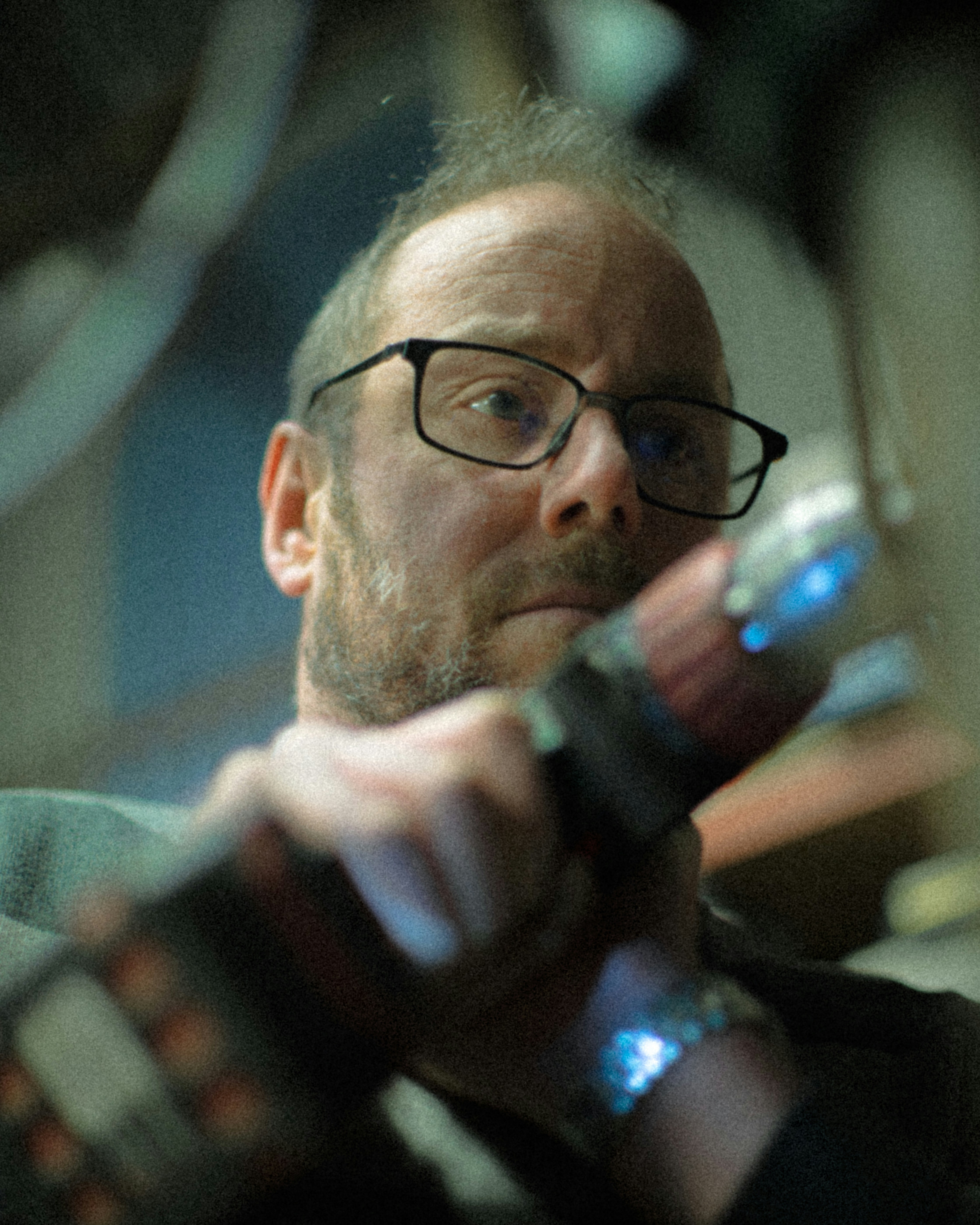 man in black framed eyeglasses drinking from bottle