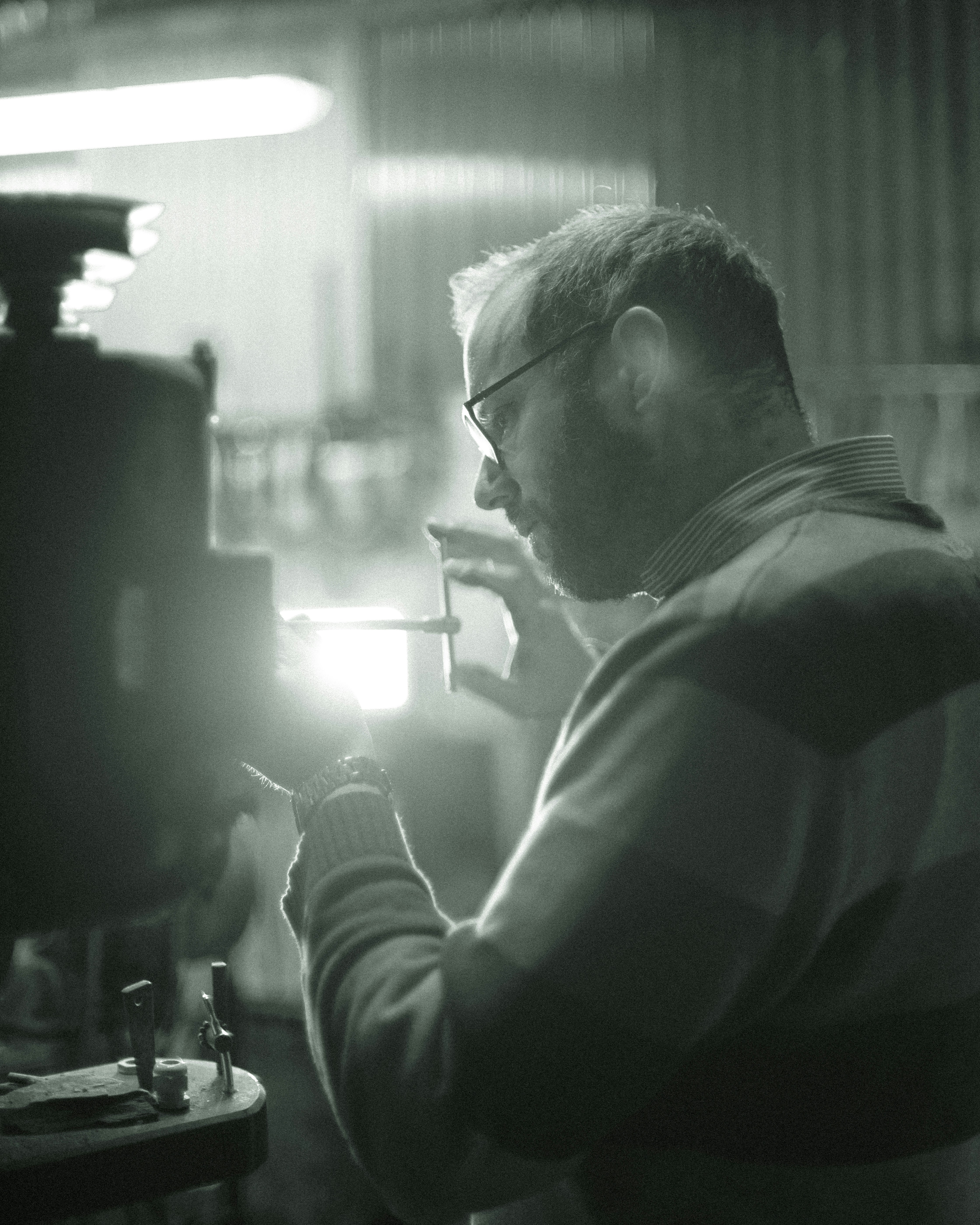 man in white and black shirt holding smartphone