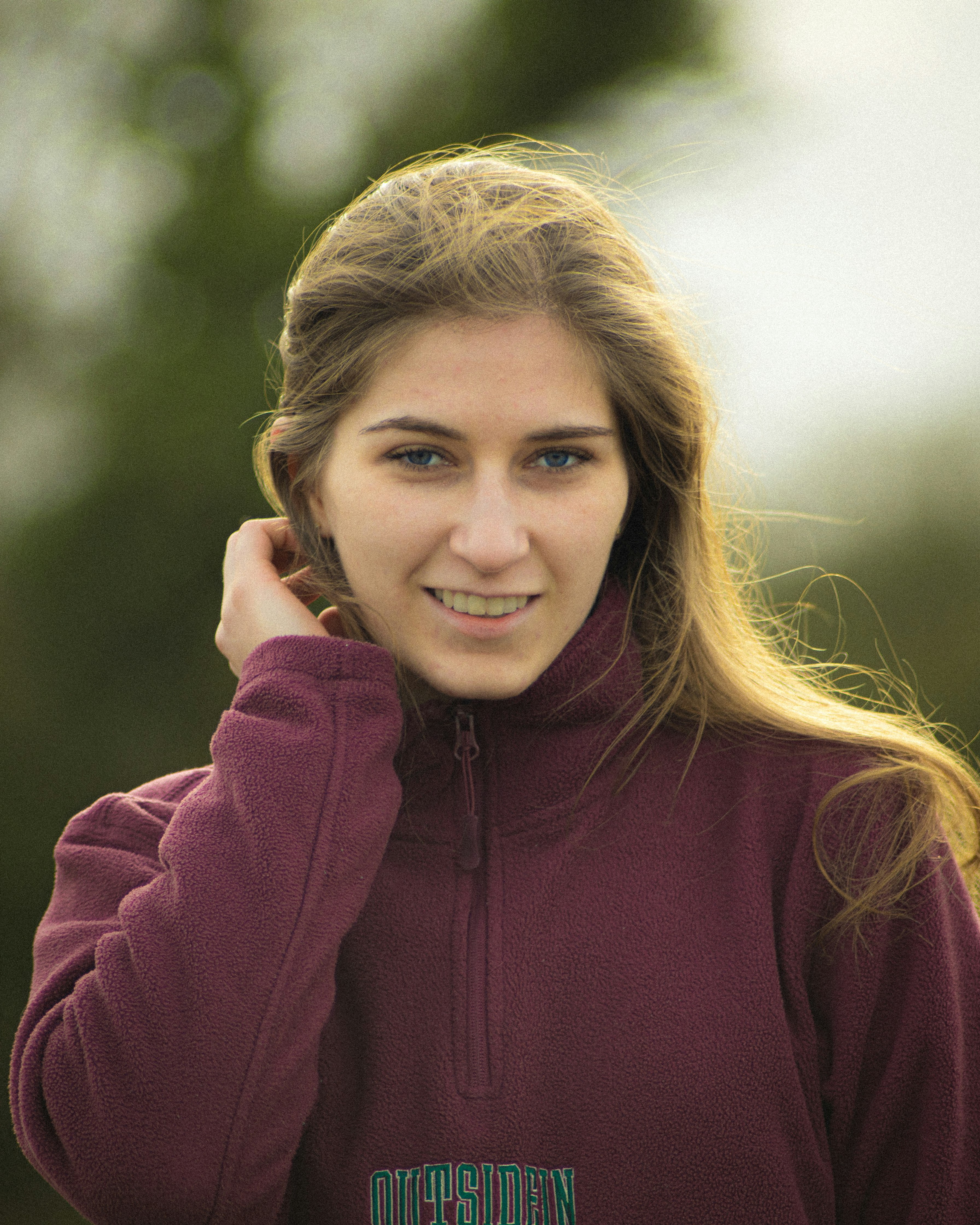 woman in maroon zip up hoodie smiling