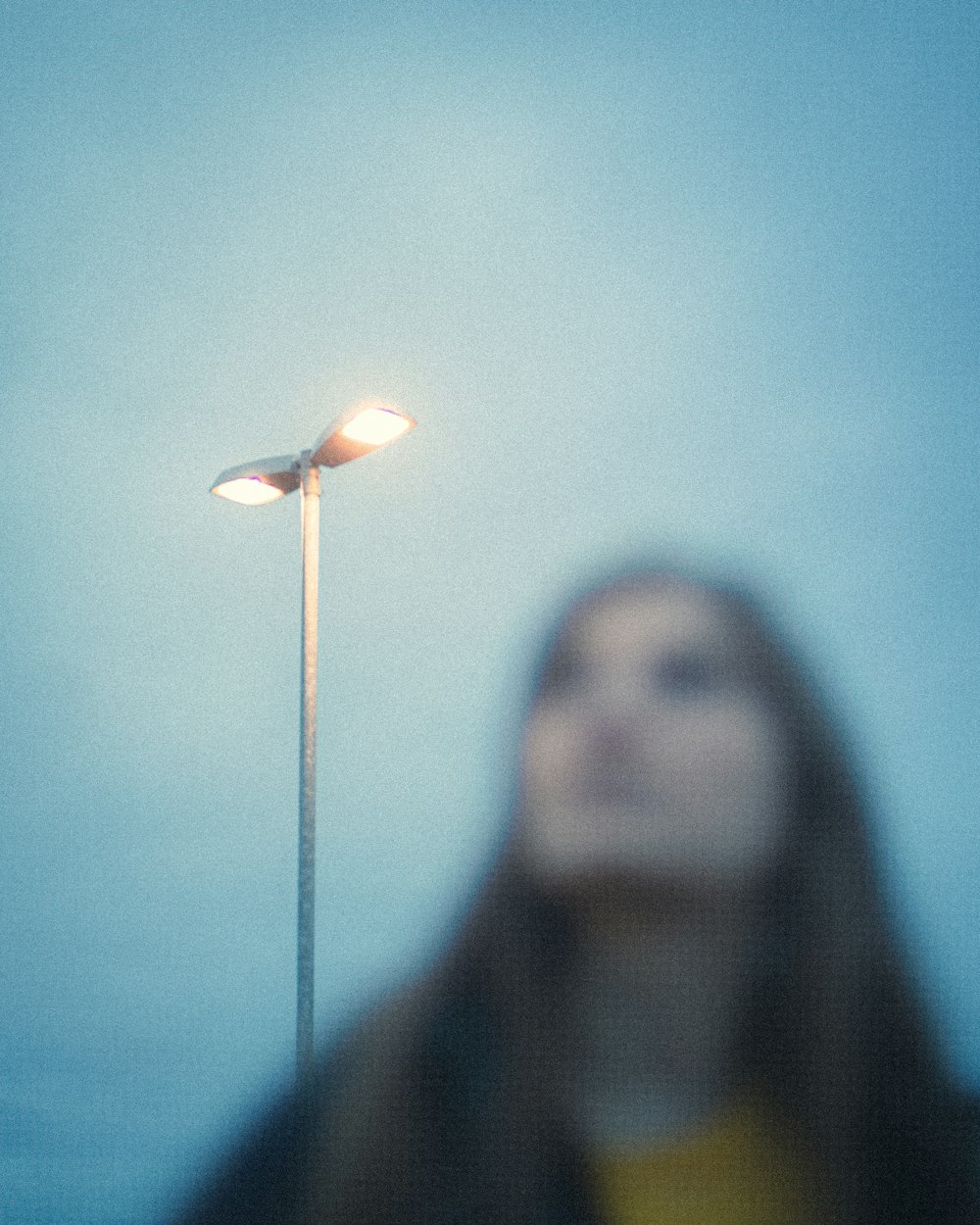 woman in black coat with white light in her face