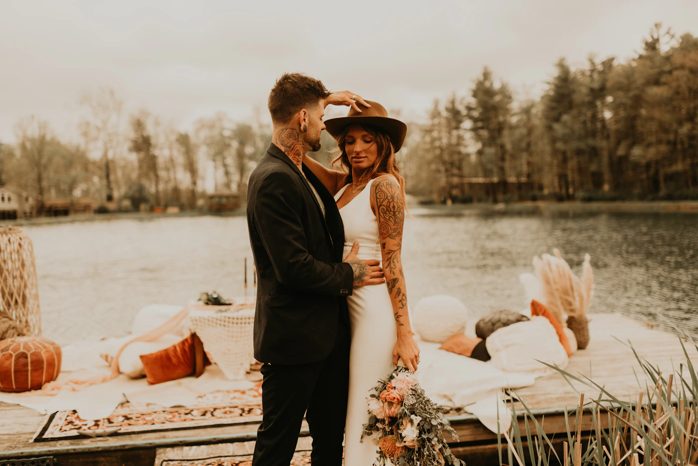 Couple in elopement attire on the shores of Lake Titicaca on the Bolivian side with the water and the island and mountains behind them