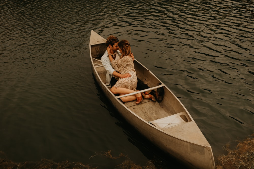 man in red and white jacket riding on brown boat during daytime