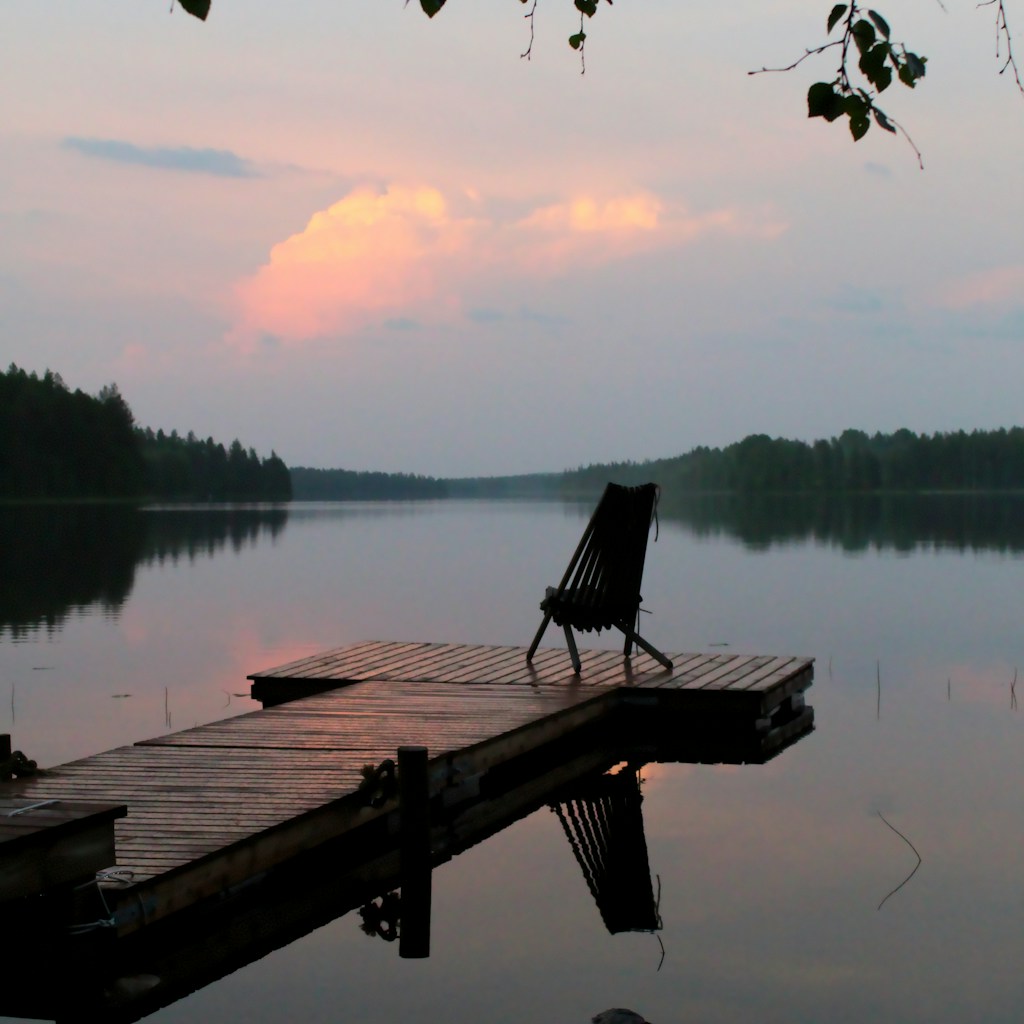 brown wooden bench on dock near lake during daytime