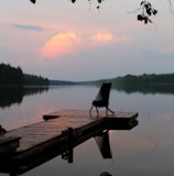 brown wooden bench on dock near lake during daytime