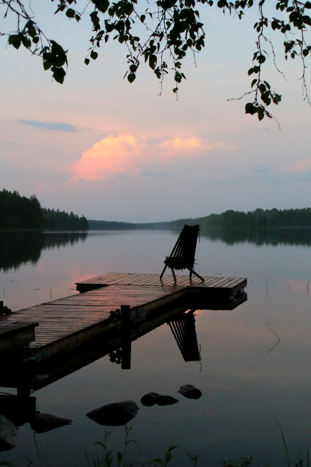 brown wooden bench on dock near lake during daytime