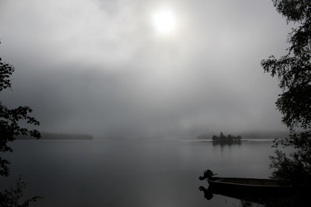 person sitting on wooden dock over calm water during daytime