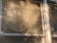 Sunlight filters through partially closed blinds, casting warm shadows on the window frame. A delicate lace curtain peeks through the slats, adding a touch of decorative detail.