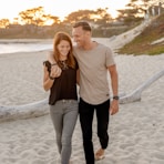 man and woman standing on beach during daytime