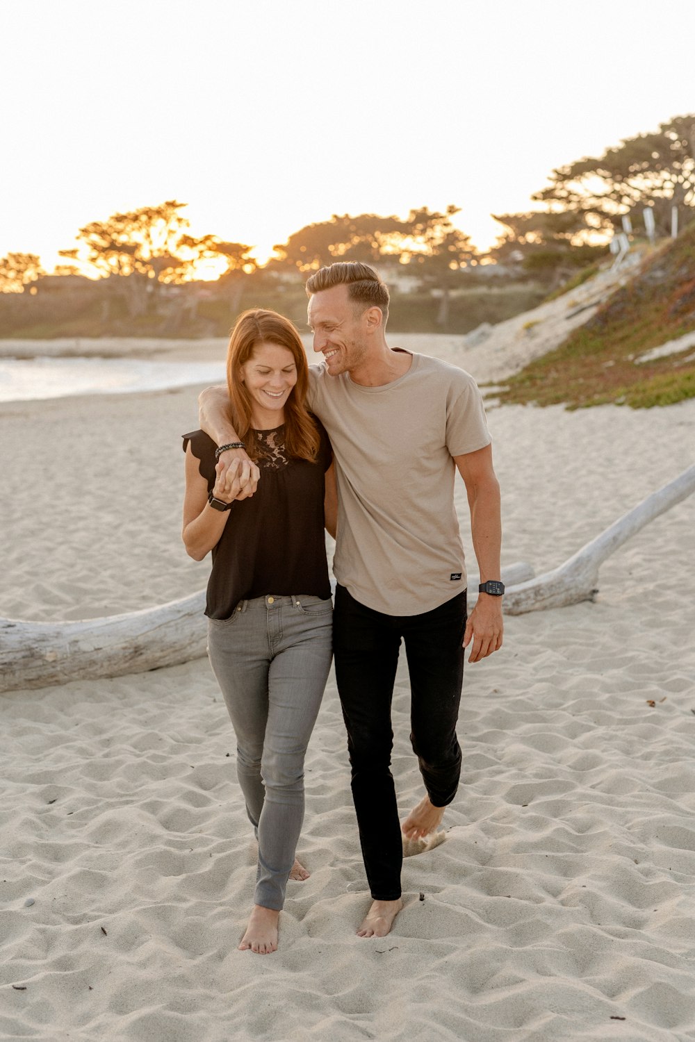 man and woman standing on beach during daytime