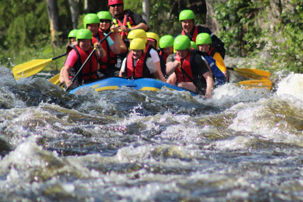 A vibrant rafting group navigating lively river rapids surrounded by lush green forest.