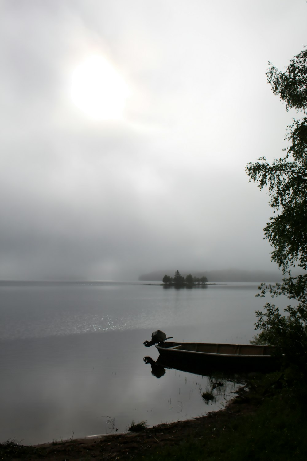 Persona che si siede sul molo di legno marrone sopra il lago