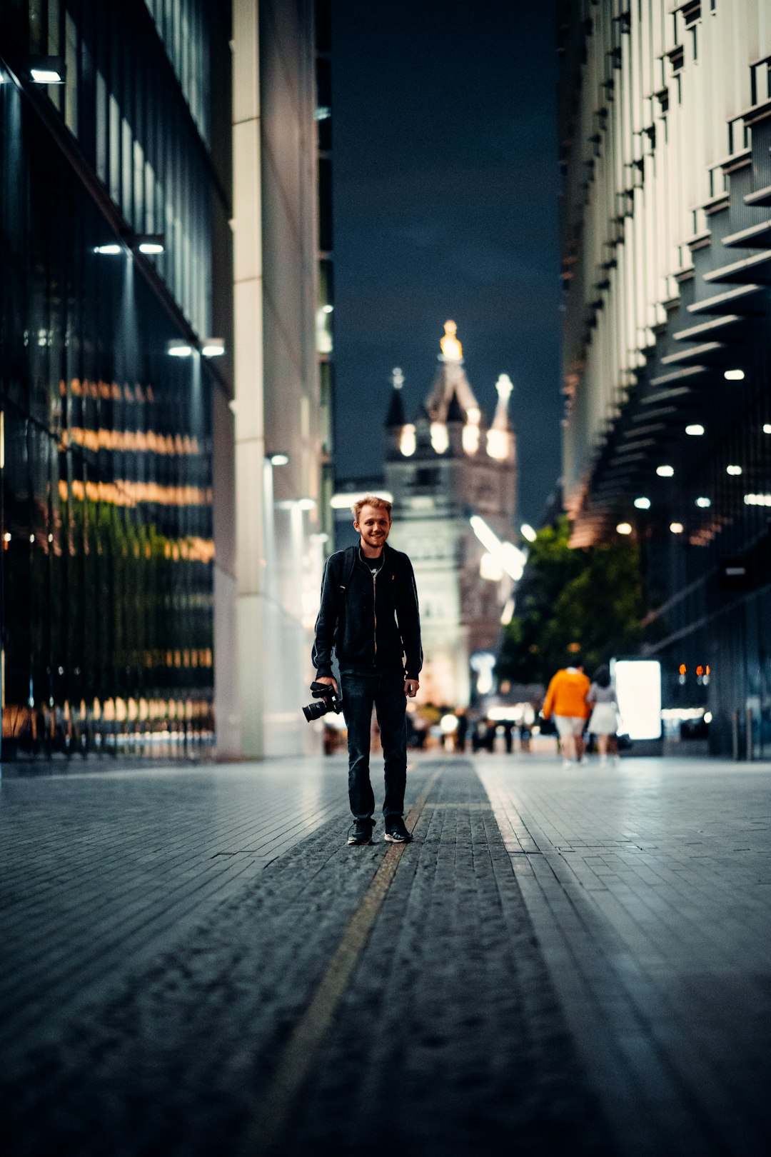 man in black jacket walking on sidewalk during night time