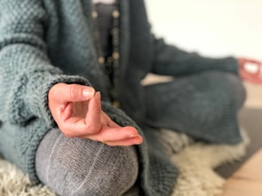 Close-up of hands in a mudra gesture resting peacefully on knees during meditation