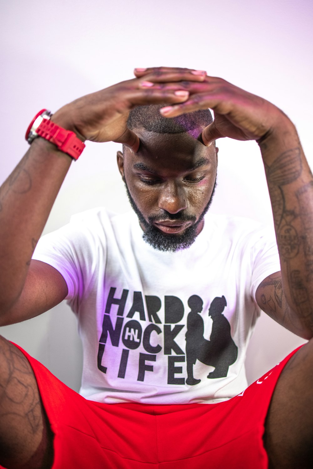 man in white crew neck t-shirt with red and black watch