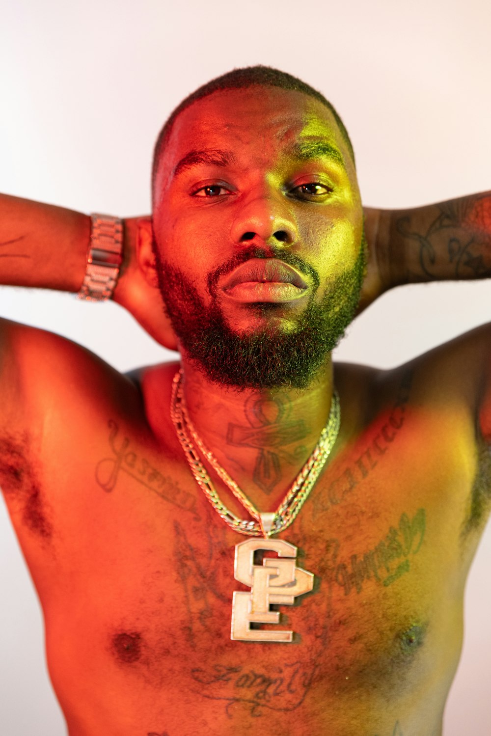 man in red tank top with green powder on his face