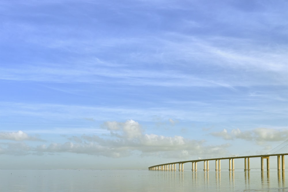 white bridge over the sea under blue sky