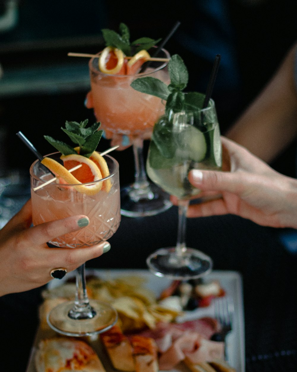 person holding clear wine glass with orange juice