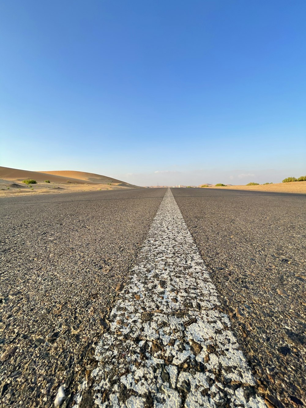 gray and white road under blue sky during daytime