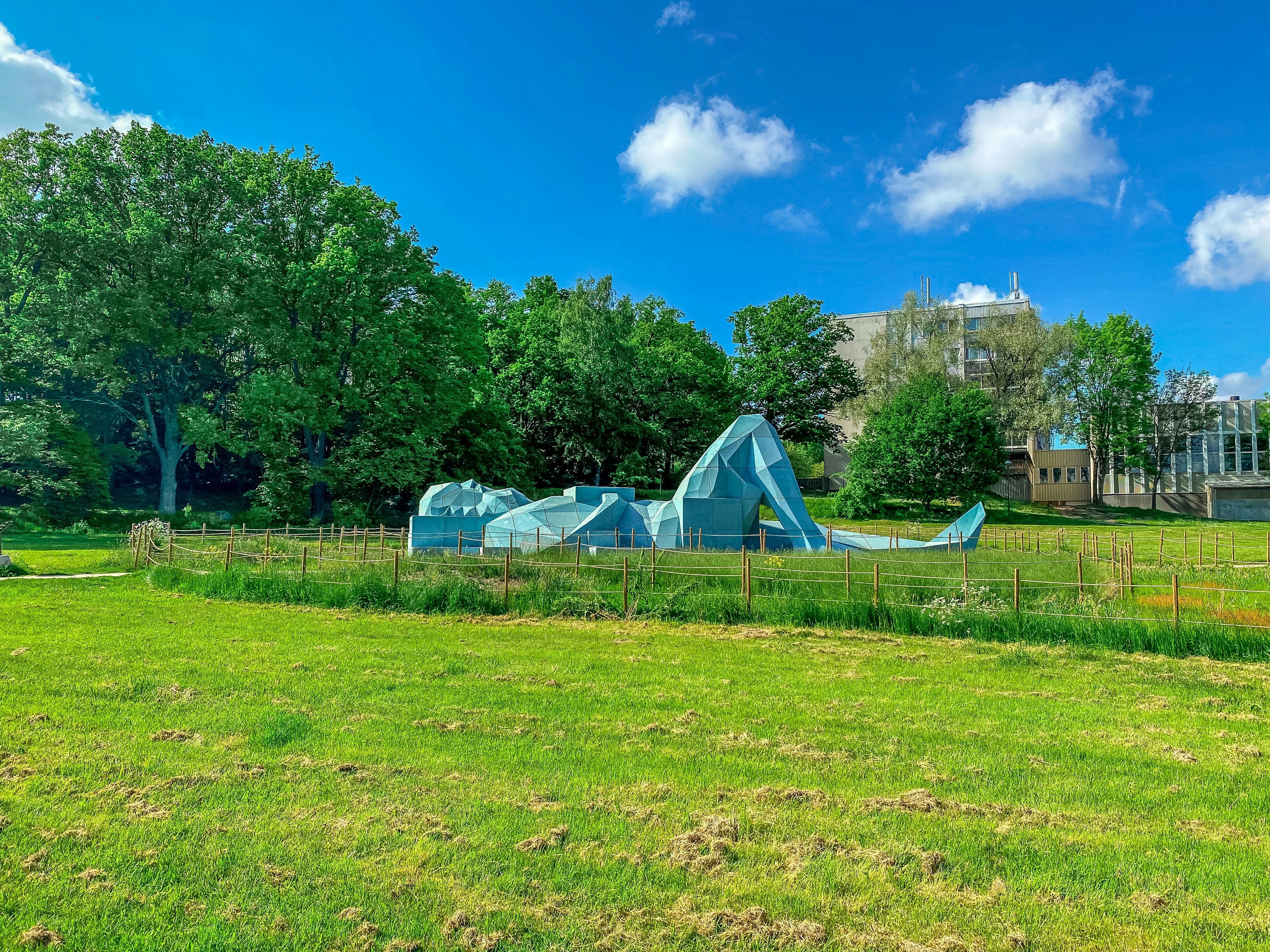 white tent on green grass field near green trees under blue sky during daytime