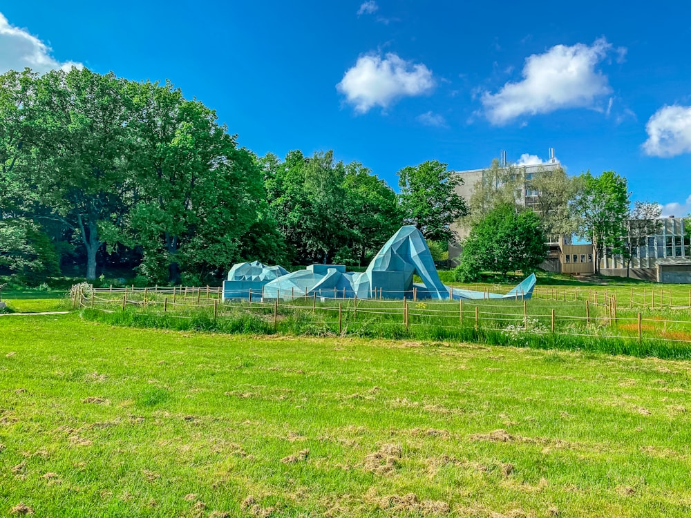 tenda branca no campo de grama verde perto de árvores verdes sob o céu azul durante o dia