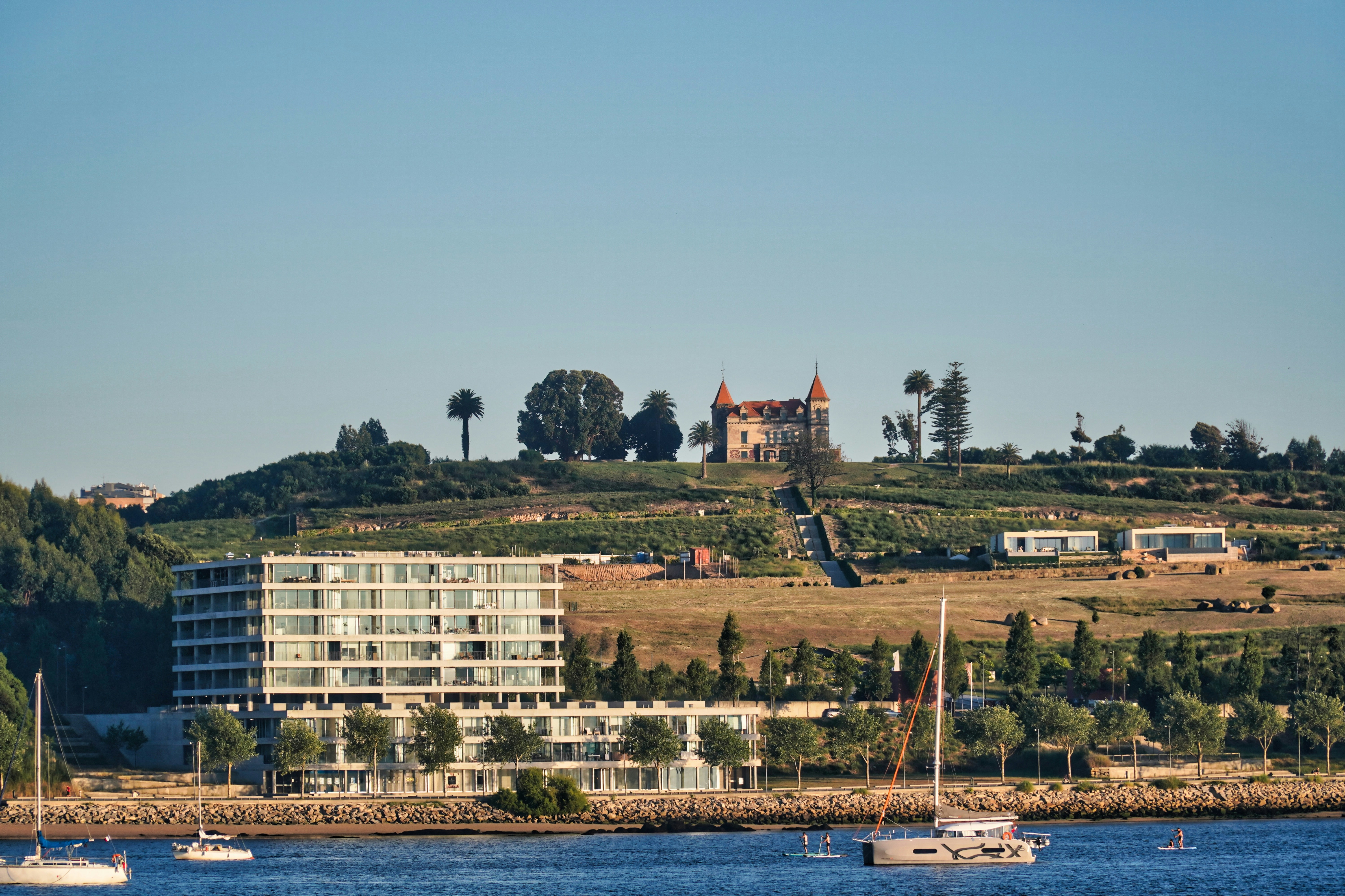 white and brown boat on water near city buildings during daytime