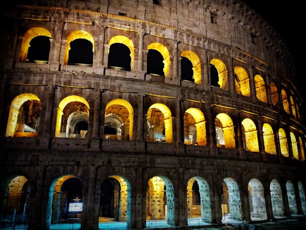 The historic Colosseum in Rome illuminated warmly during twilight.