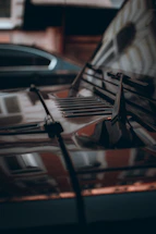 A close-up of a shiny, freshly detailed car hood reflecting the Chicago skyline on a sunny day.