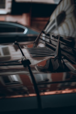 A close-up of a shiny, detailed car hood reflecting sunlight.