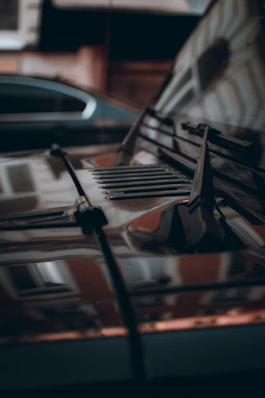 Close-up of a car's glossy red hood with reflections.