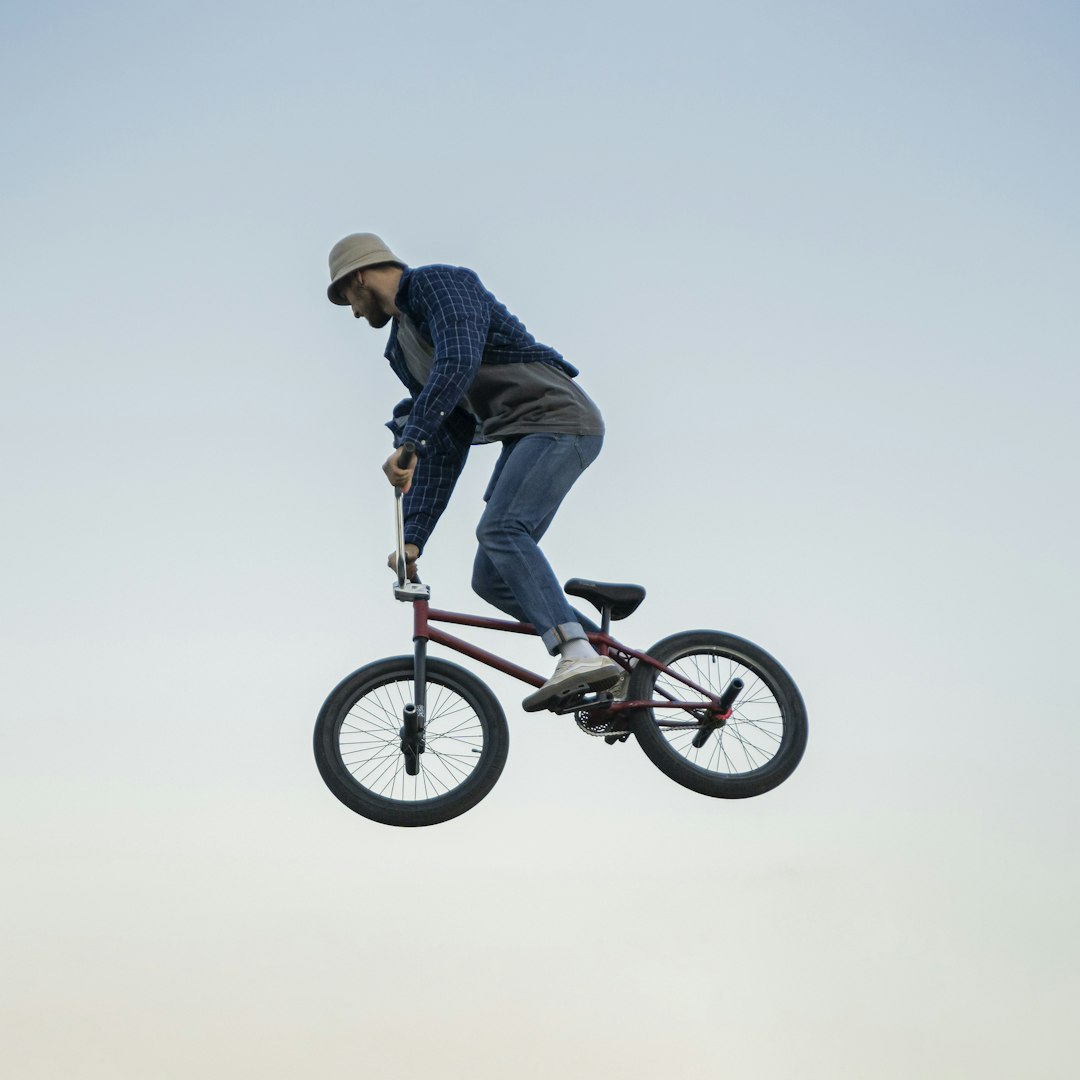 man in blue and white plaid dress shirt riding on bmx bike