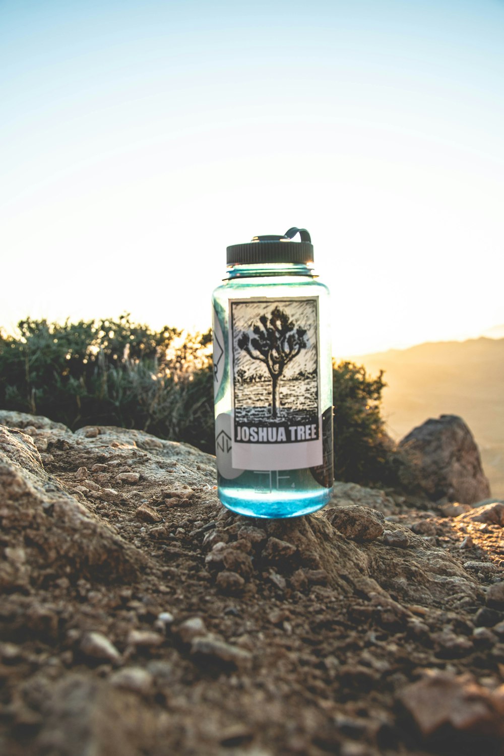 blue and white floral glass bottle on brown rock during daytime