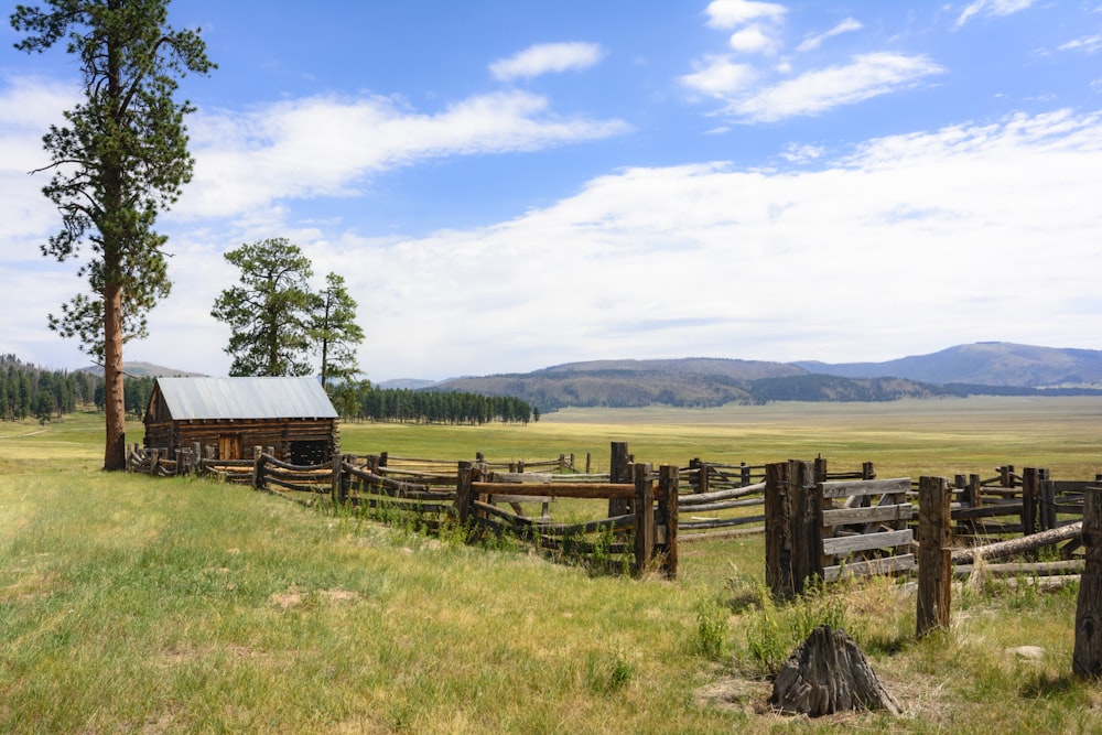 brown wooden fence on green grass field during daytime