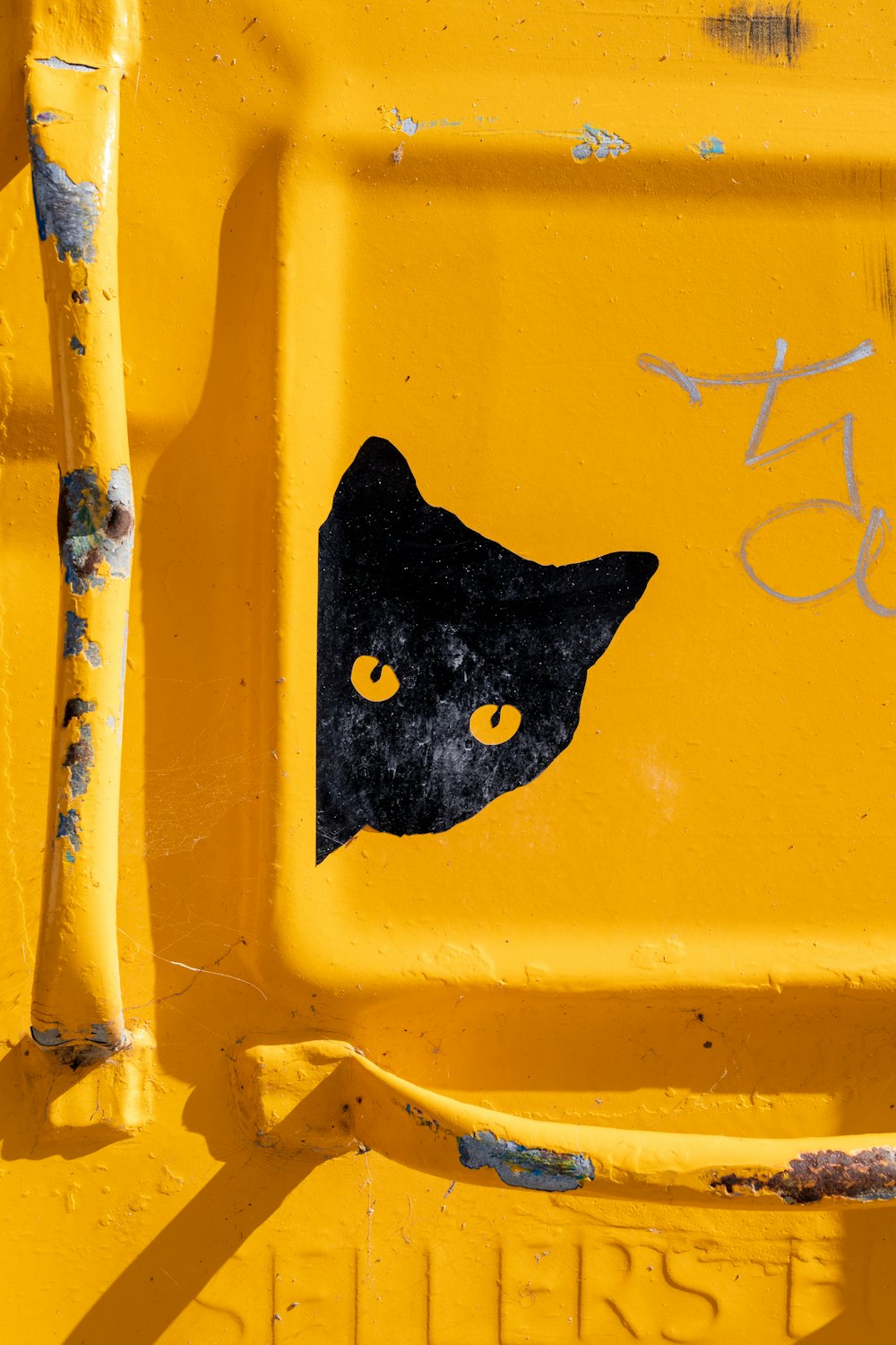 chat noir sur barre en métal jaune