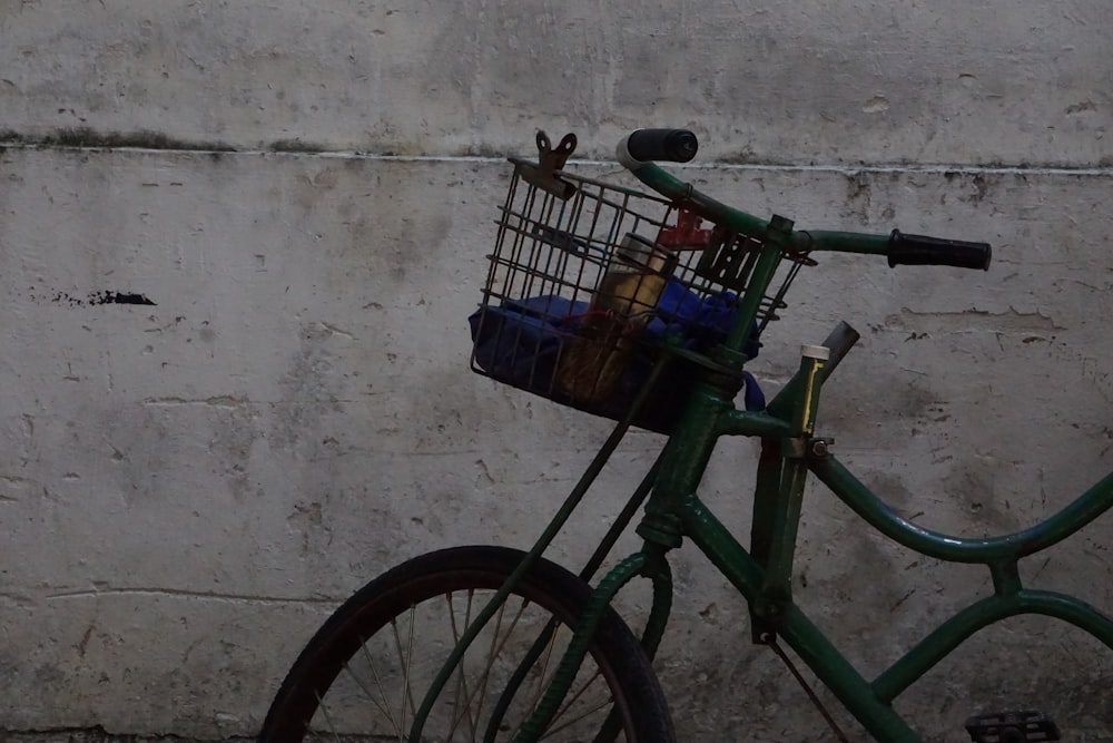 Bicicleta urbana verde con cesta en la parte superior