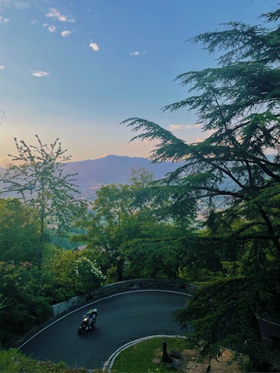 A scenic view of a motorcycle riding along a winding mountain road.