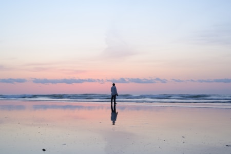 woman standing on beach during sunset