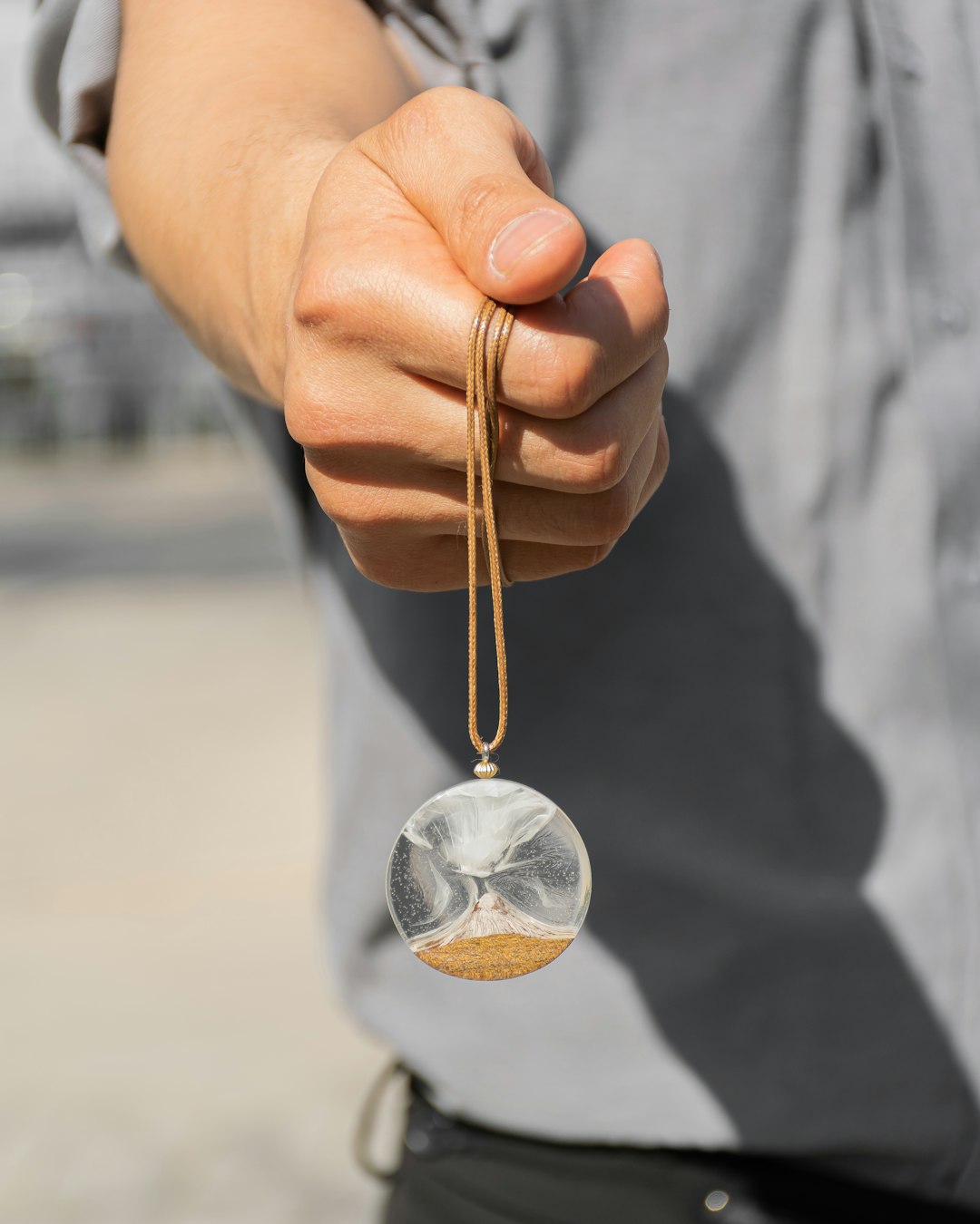 person holding silver heart pendant