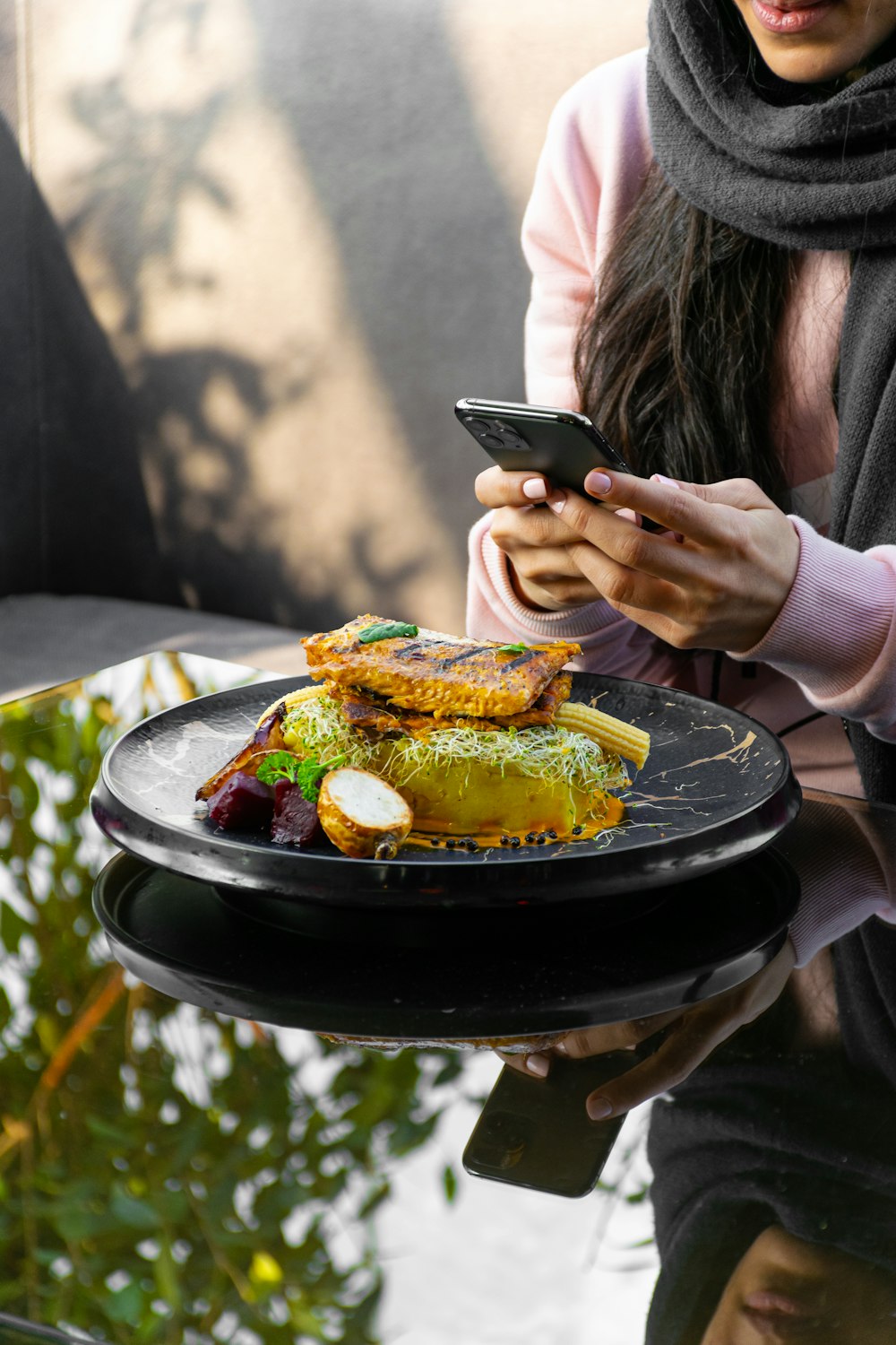 woman holding black smartphone while eating