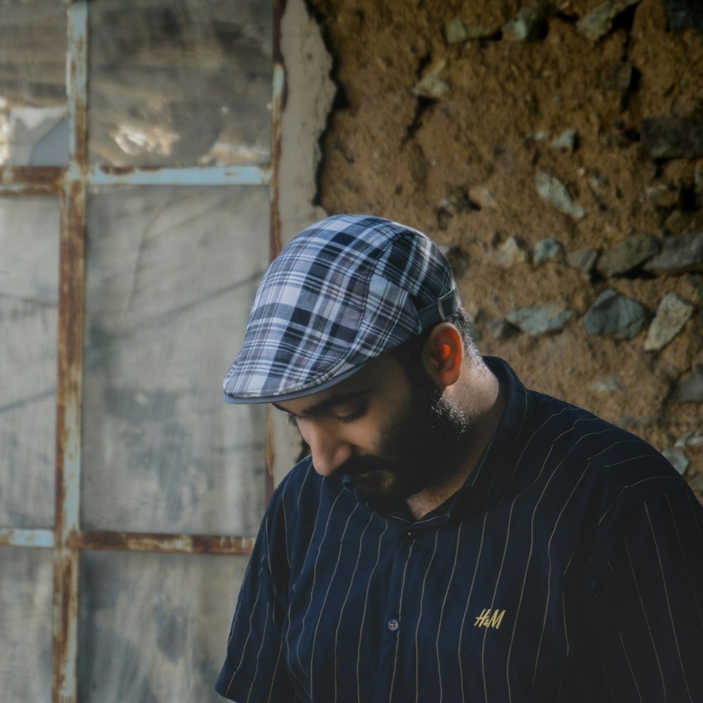 man in black long sleeve shirt wearing white and blue plaid cap