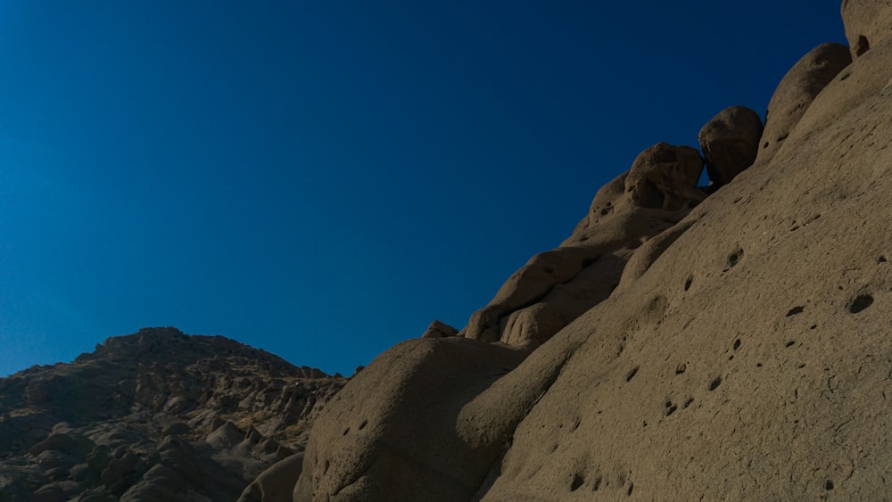montanha rochosa marrom sob o céu azul durante o dia