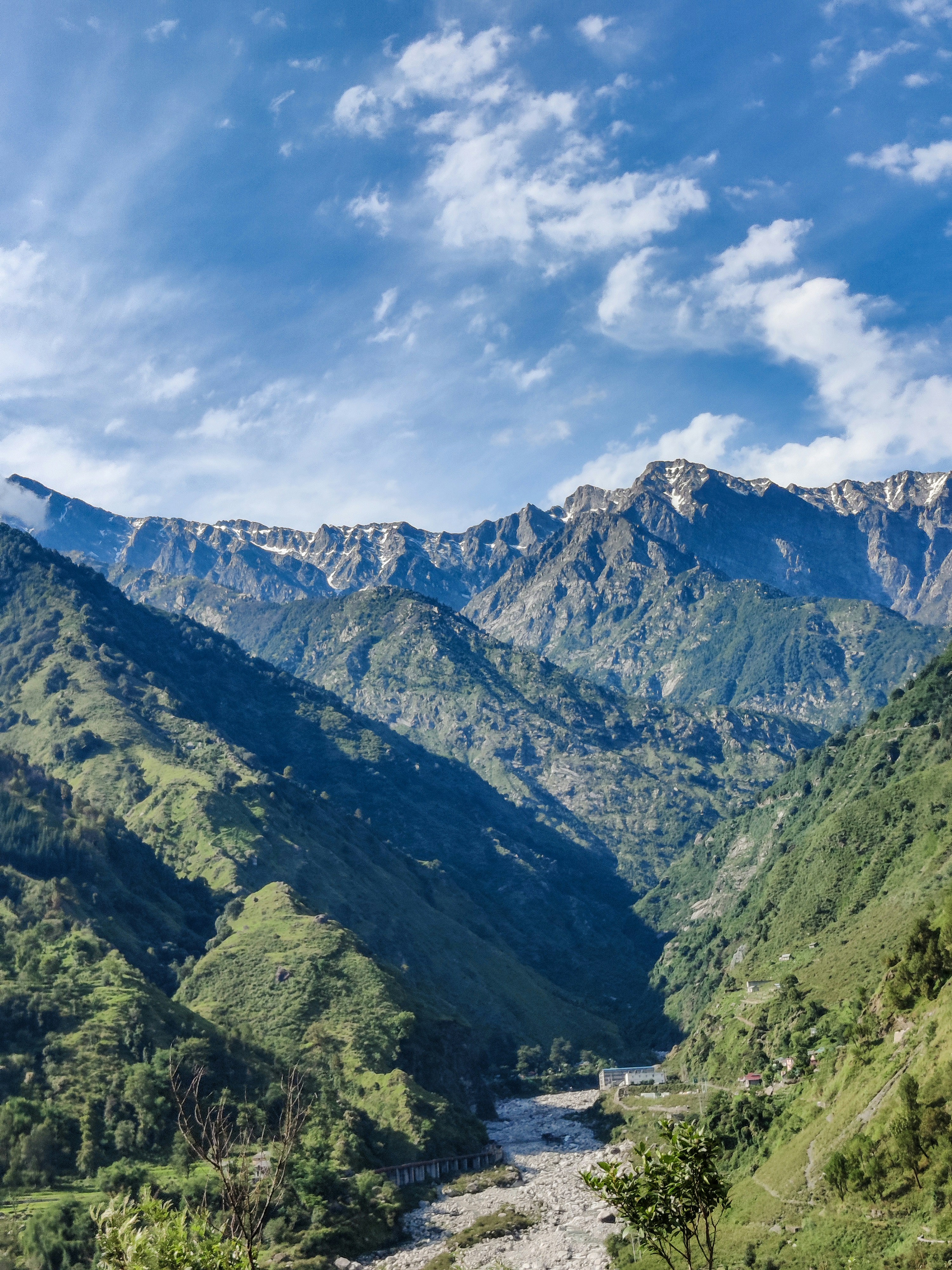 green and brown mountains under white clouds and blue sky during daytime